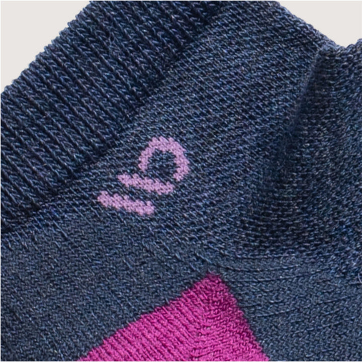 detail image of 9500 Denim, featuring a Lavender logo and fuchsia heal, with solid denim body