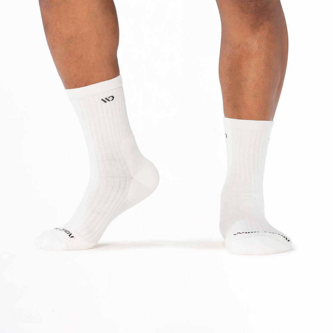 Model image lifting the left foot onto toes wearing the 9001 in white colorway