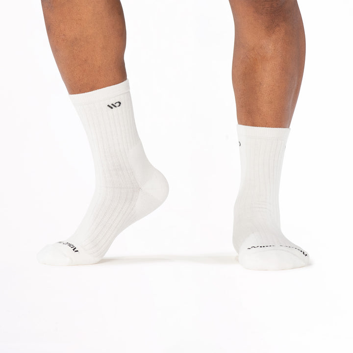 Model image lifting the left foot onto toes wearing the 9001 in white colorway