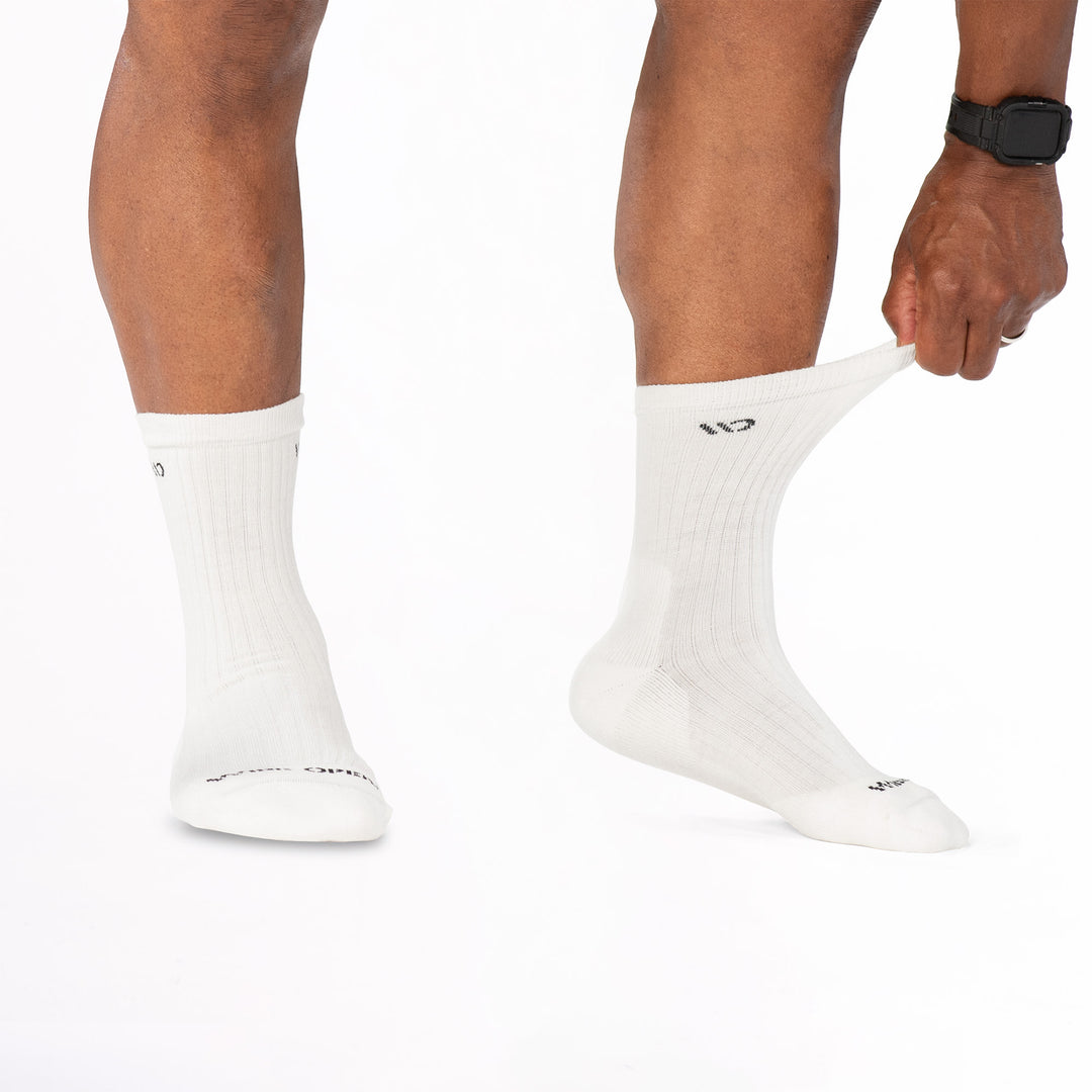 Model stretching the cuff of the sock on the right wearing the 9001 in white