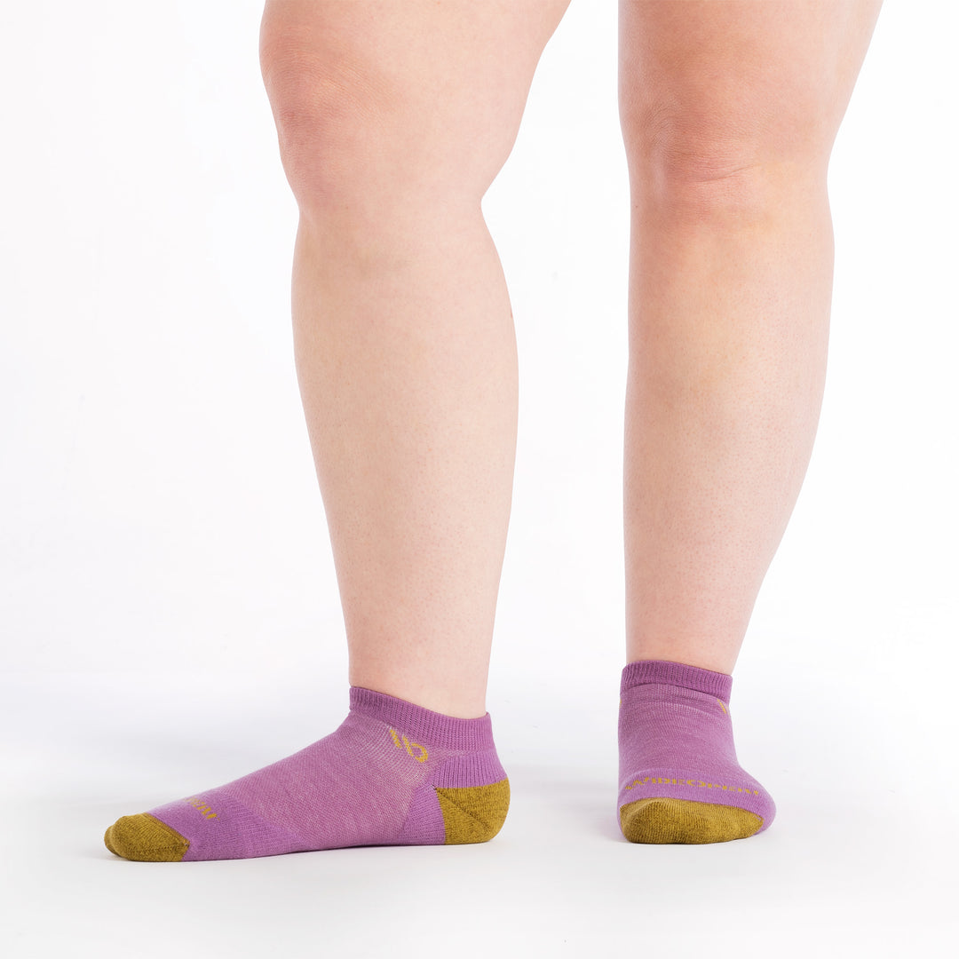 on model image with one foot to the side wearing the 9500 solid no show in violet