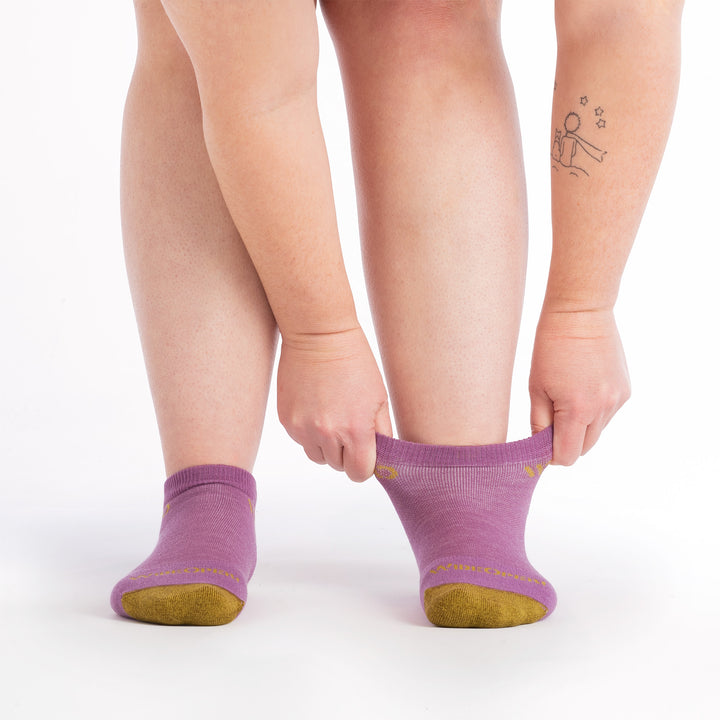 on model image of model stretching the top cuff of the 9500 solid no show in violet