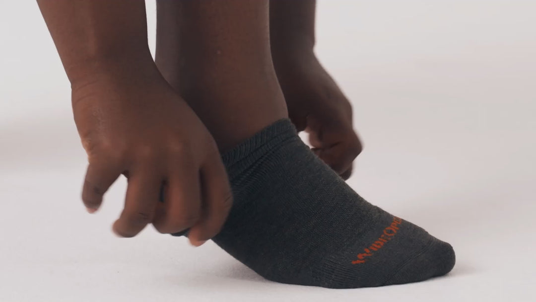 Model putting on, adjusting and standing in WIDE OPEN socks.