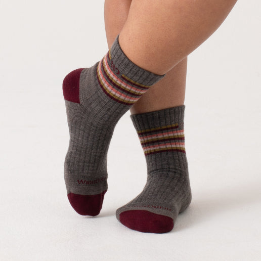 A pair of crossed feet wearing new wide socks with vintage stripes