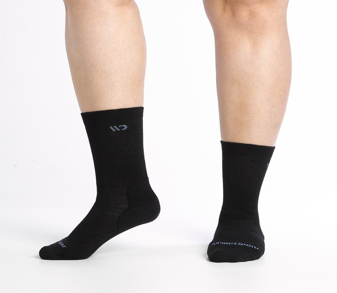 Feet wearing black socks with a wide fit and crew height