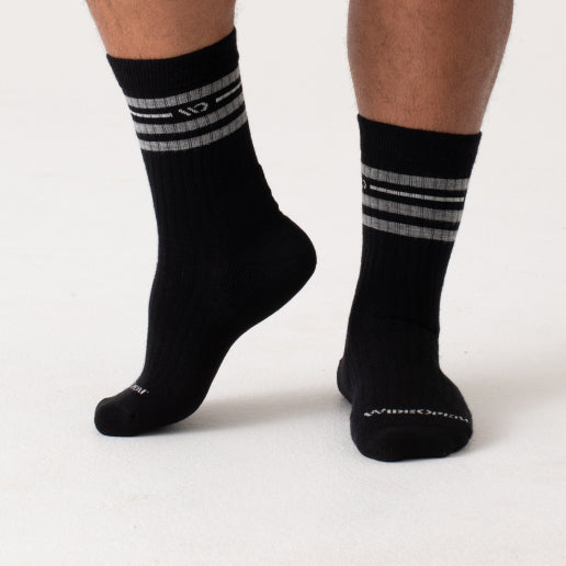 Feet wearing black socks with a wide fit and crew height