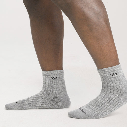 A pair of wide feet wearing gray socks