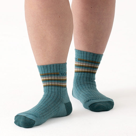 A pair of feet wearing teal socks with a wide fit and classic stripes