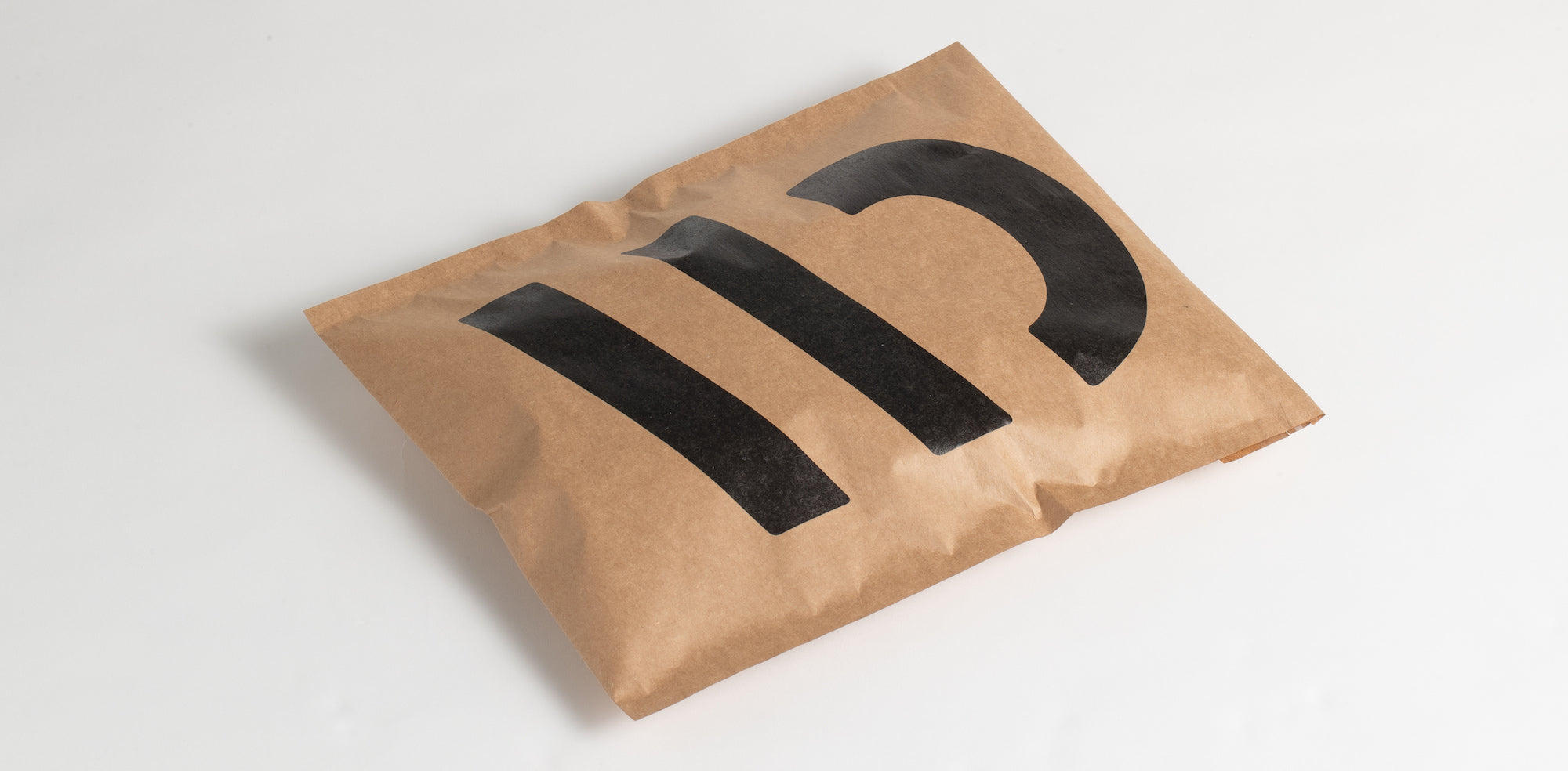 A Wide Open brown shipping bag with the Wide Open logo printed on the front.