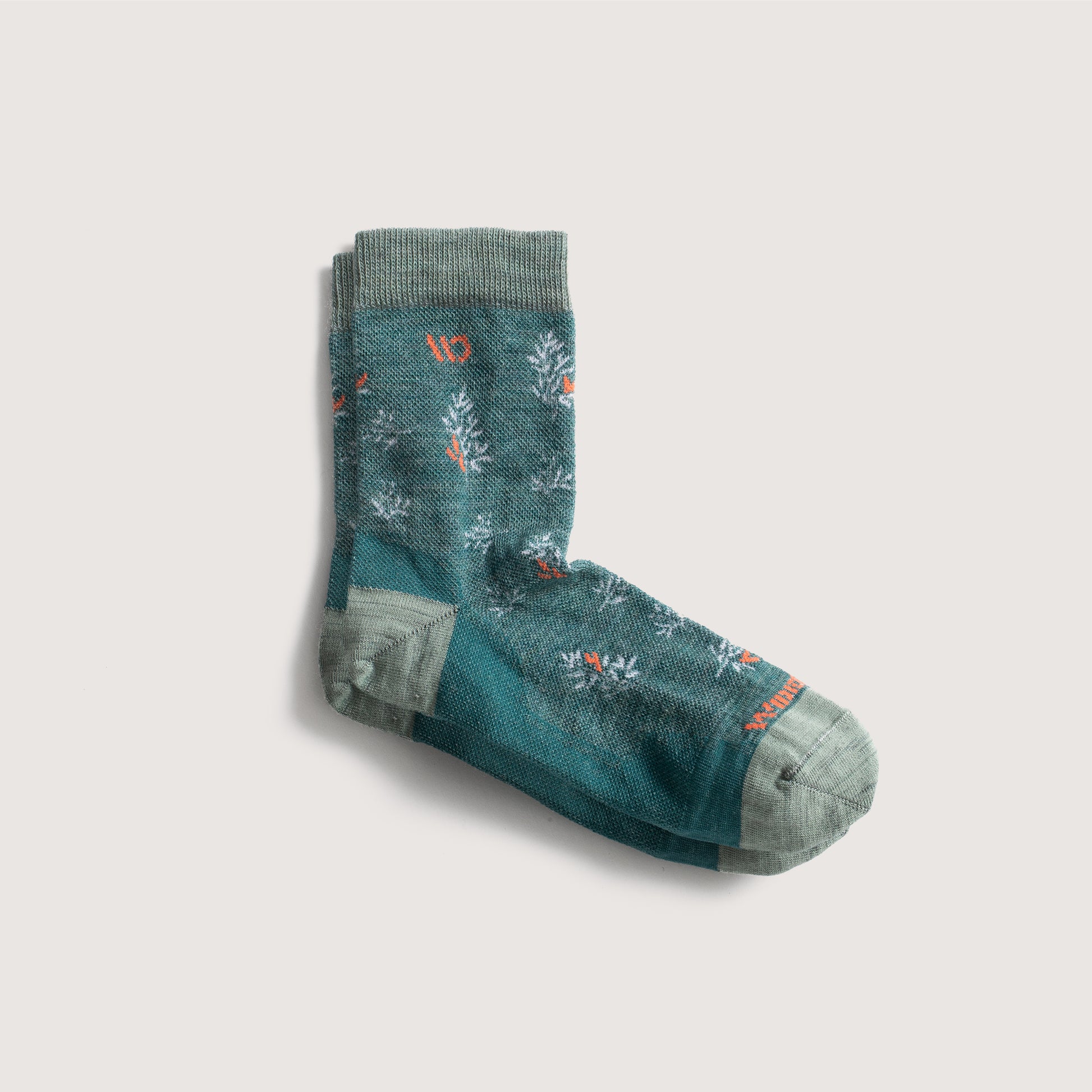 Flat socks featuring seafoam heel/toe/cuff, teal body, orange logo and white pattern--Teal