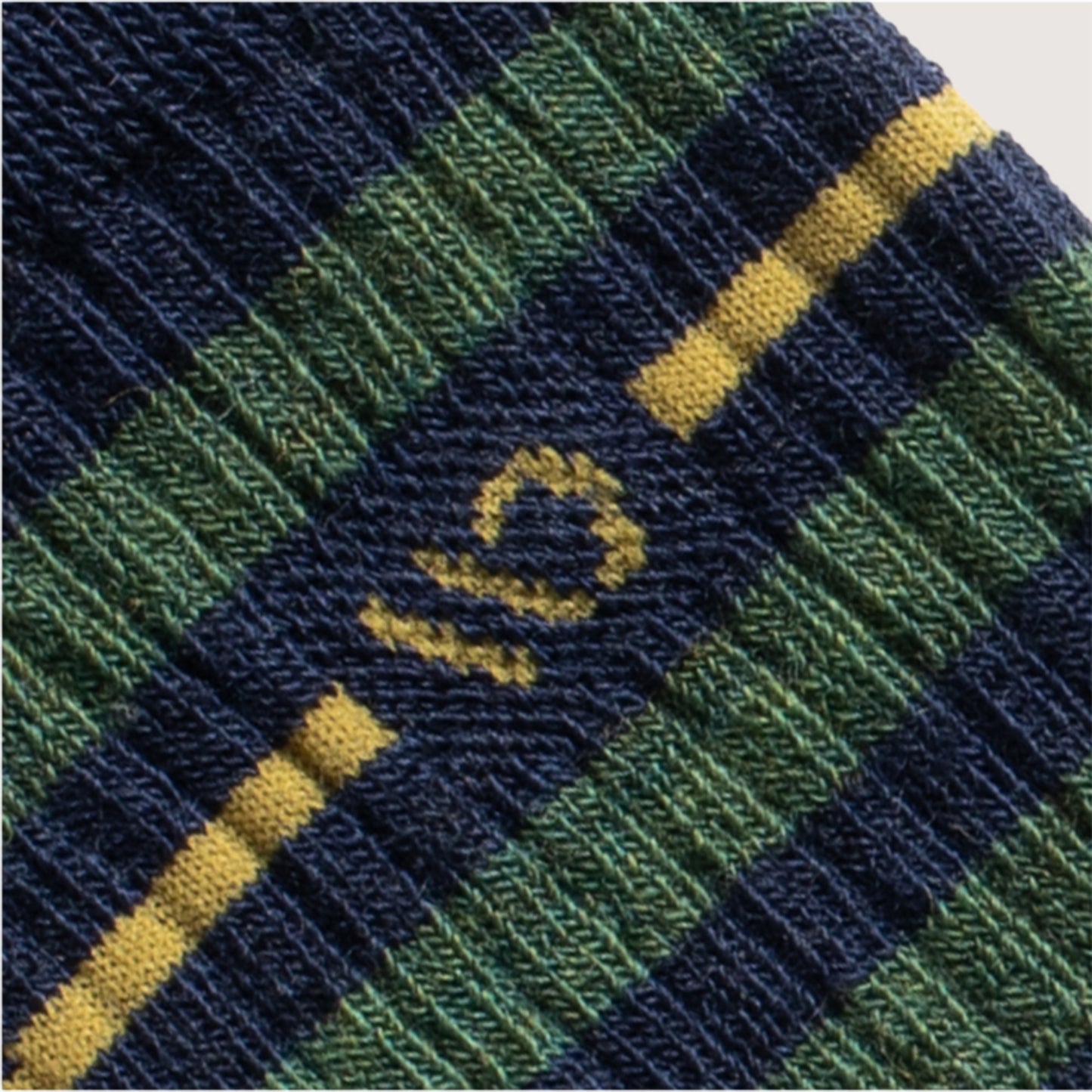Detail featuring a yellow logo and stripe, with wider denim and green stripes --Denim