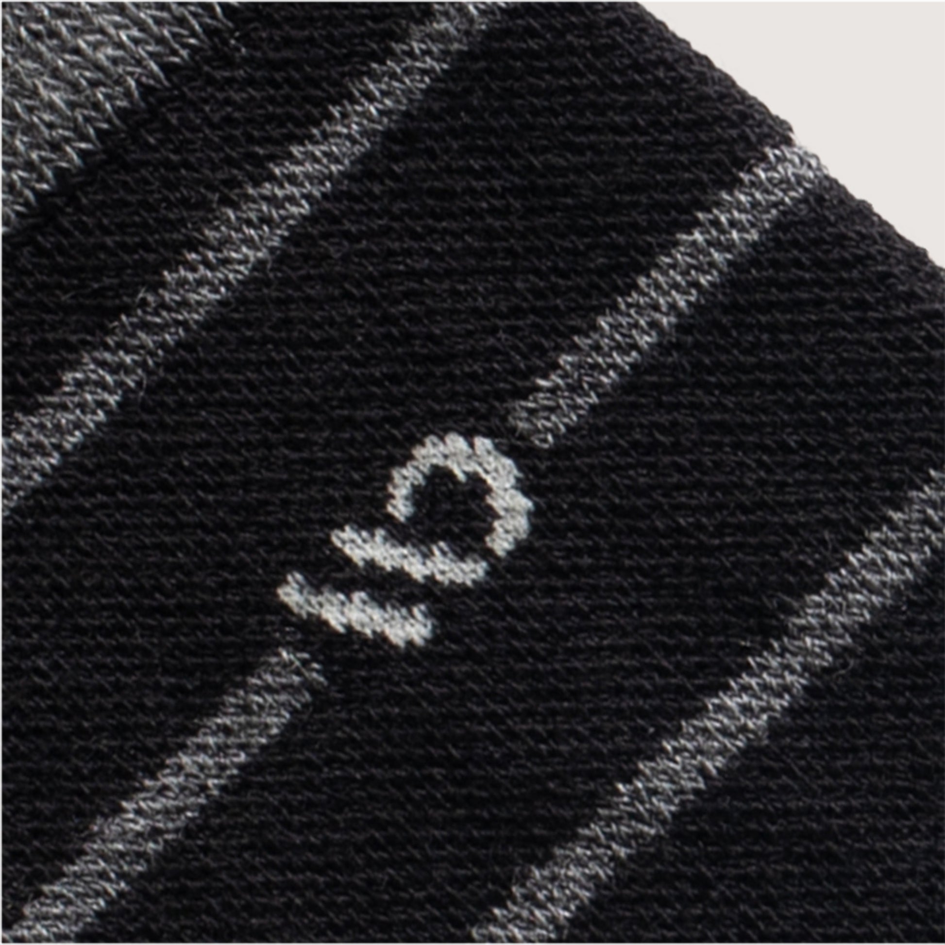 Detail image of white logo, grey stripes on a black sock --Black