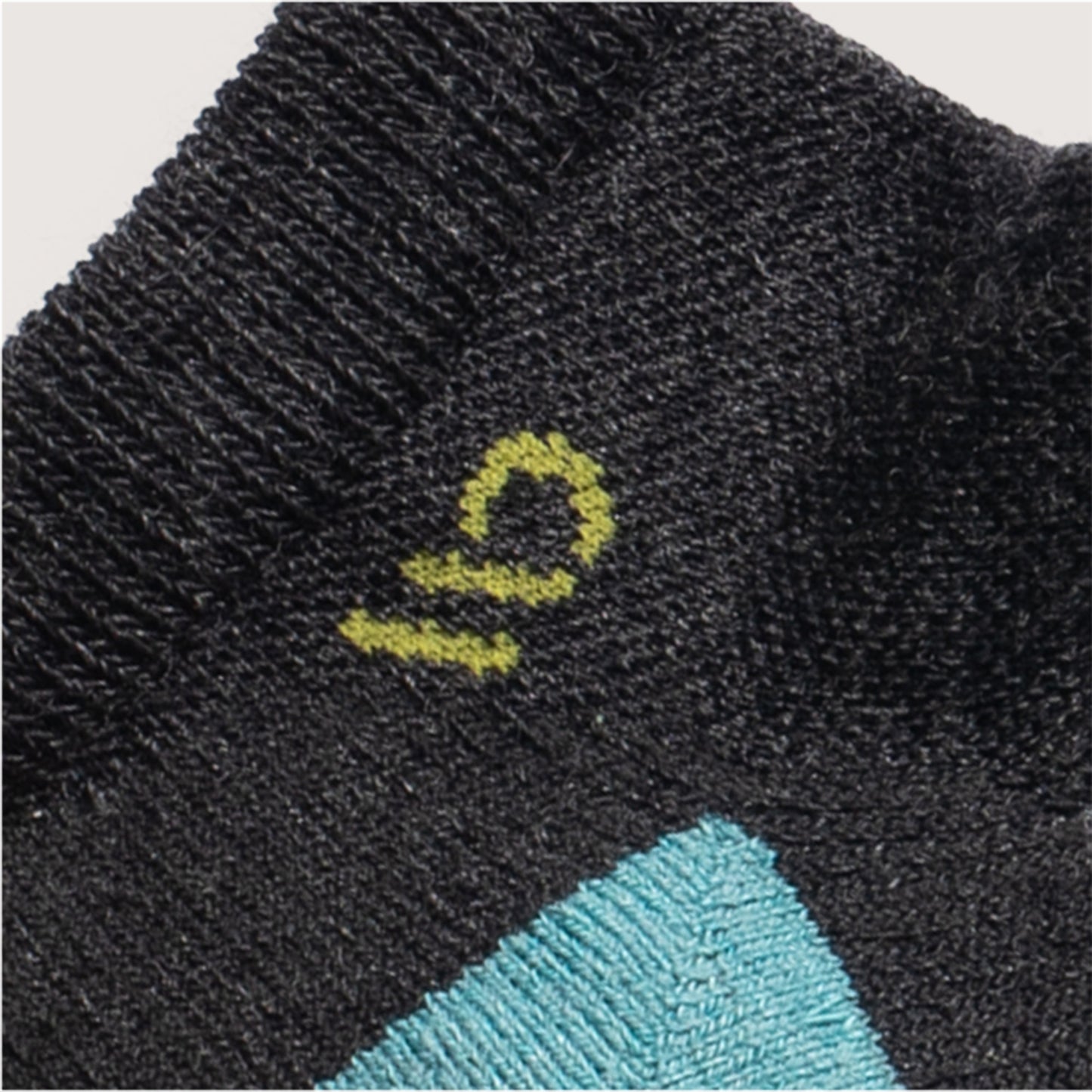Detail featuring a yellow logo and light teal heal, with solid charcoal body --Charcoal