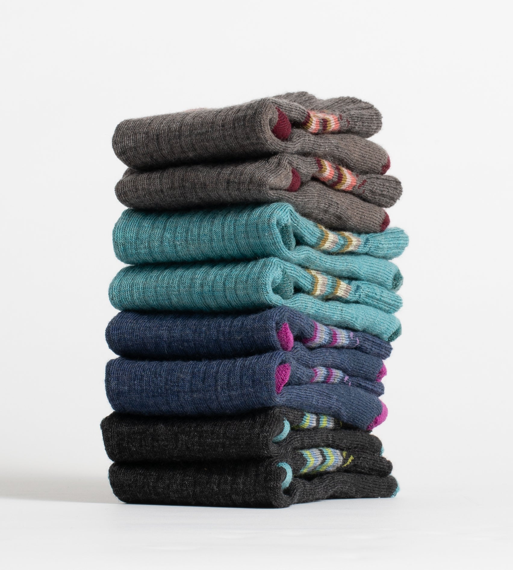 Four different colored sock pairs, folded neatly in a single stack.