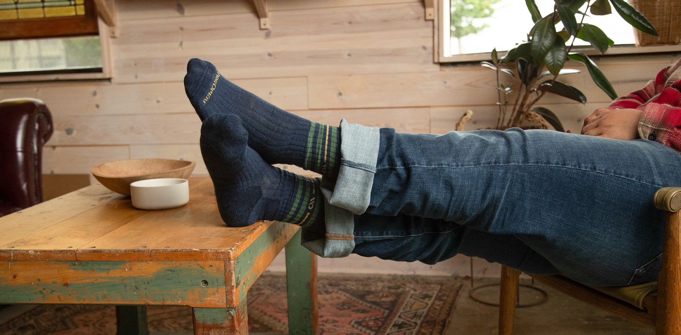 A person with feet up on a table wearing wide socks in navy blue