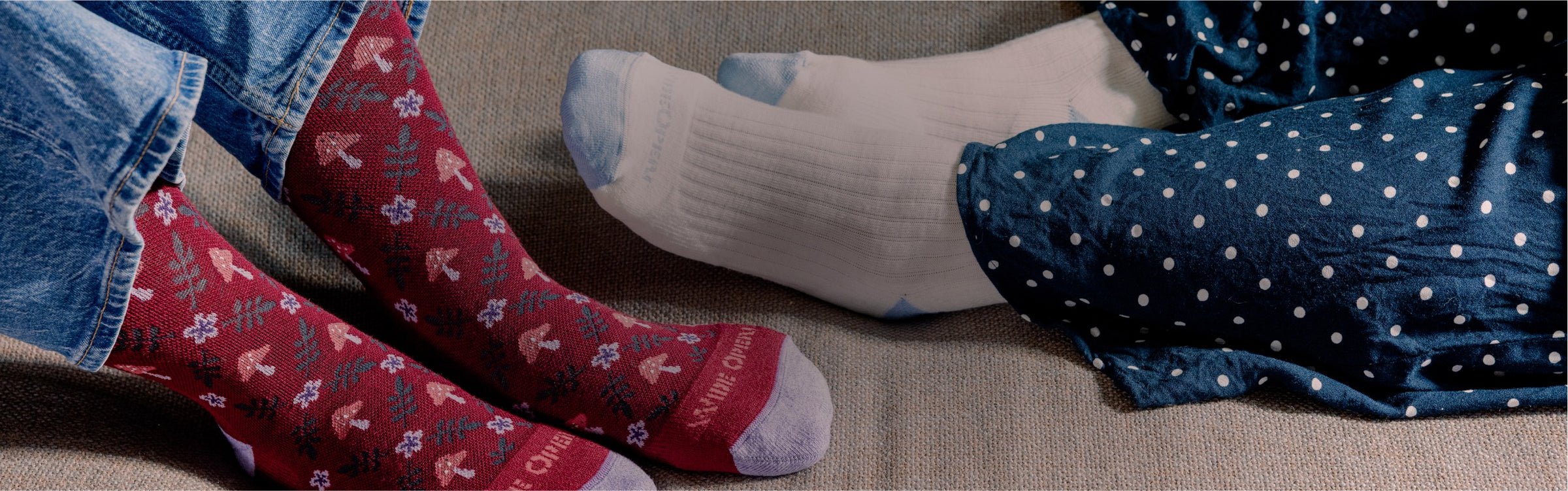 Two pairs of feet in wide width socks - white ones, and burgundy ones with mushrooms