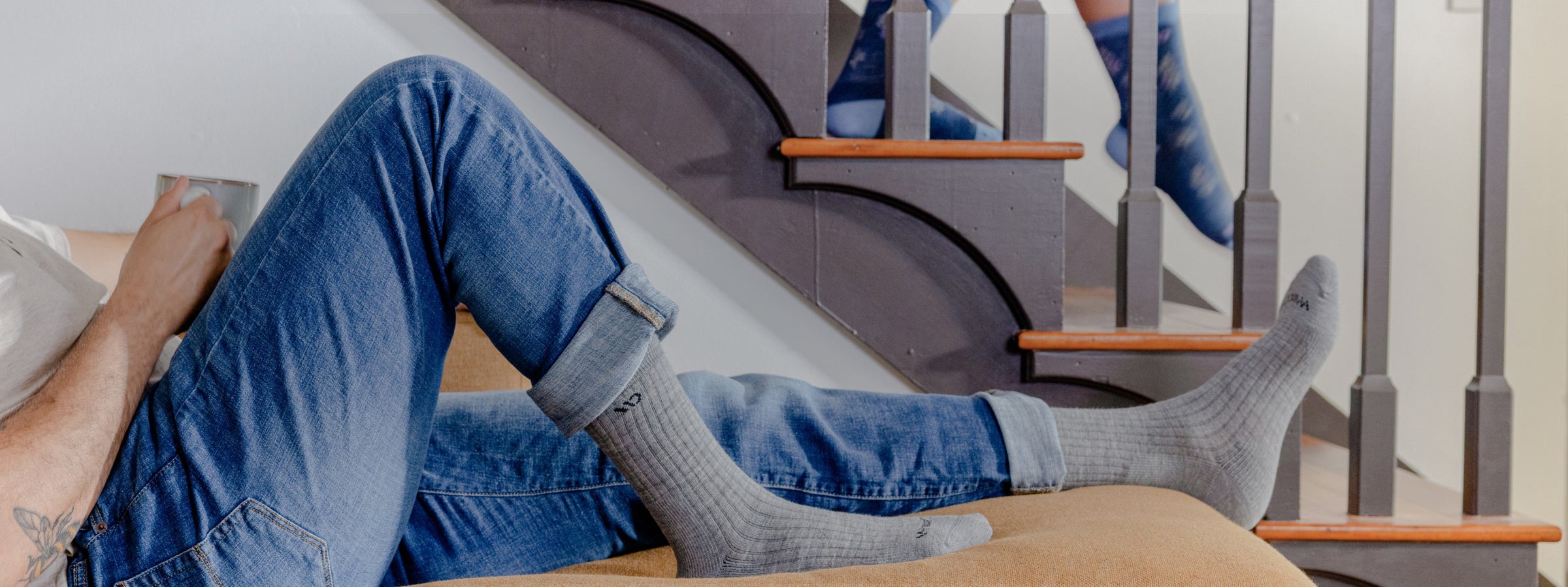 A person wearing comfortable looking socks and seated on a couch