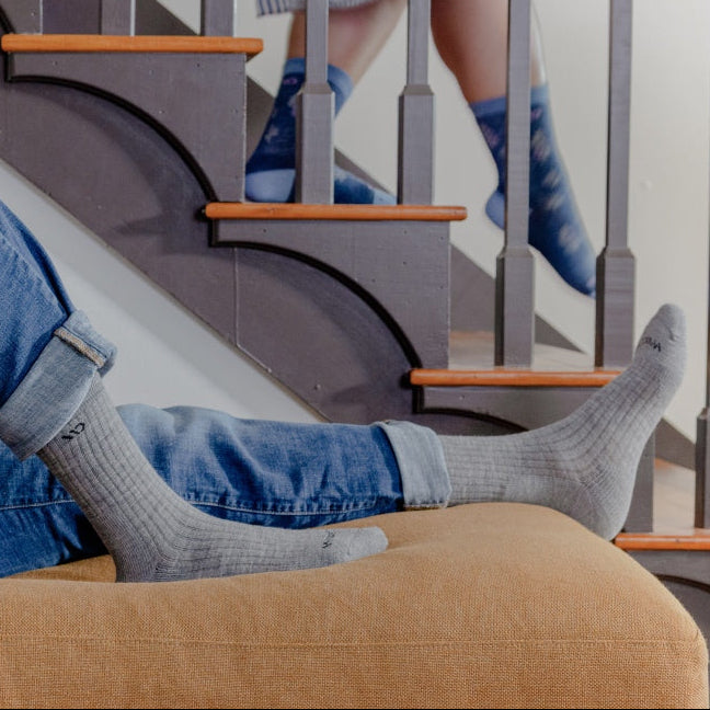 A person wearing comfortable looking socks and seated on a couch