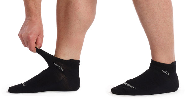 Feet wearing lightweight socks from Wide Open in an ankle height, pulling the cuff to show the stretch