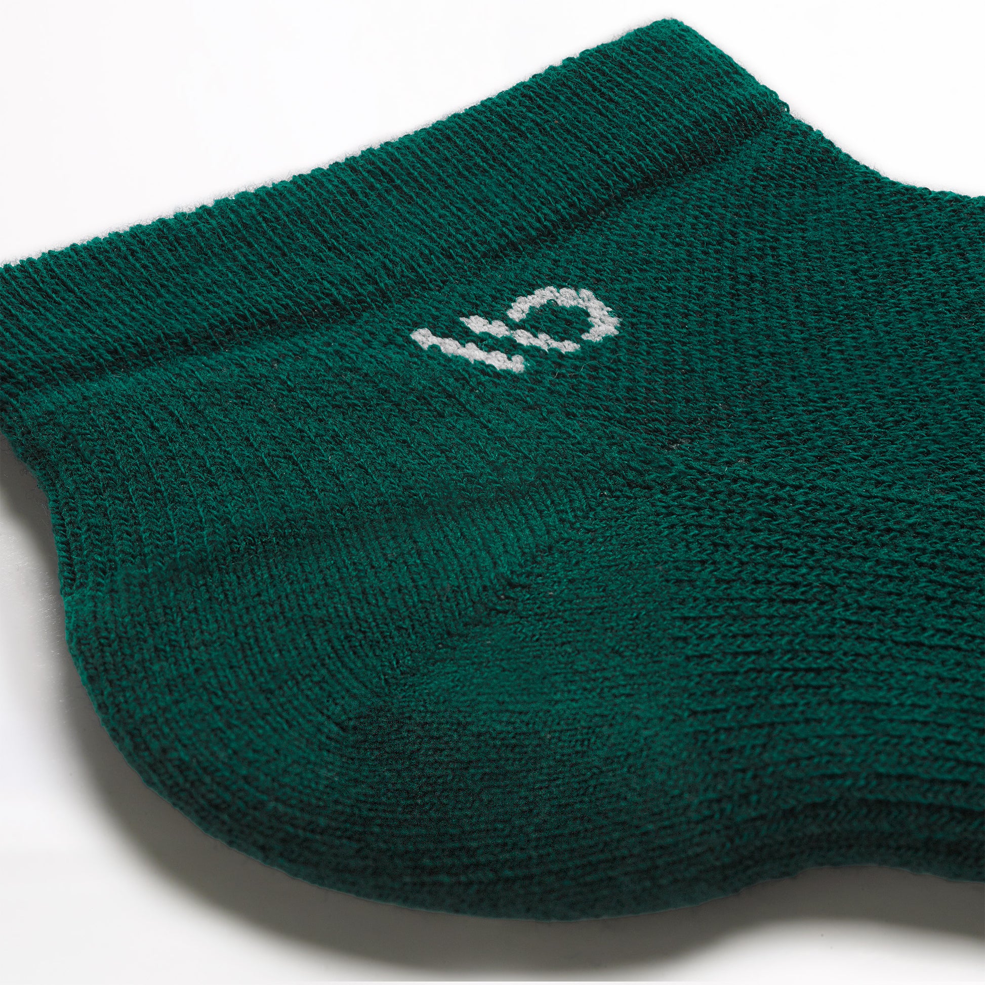 Detail image of the 9000 No show sock in spruce cuff has the white logo