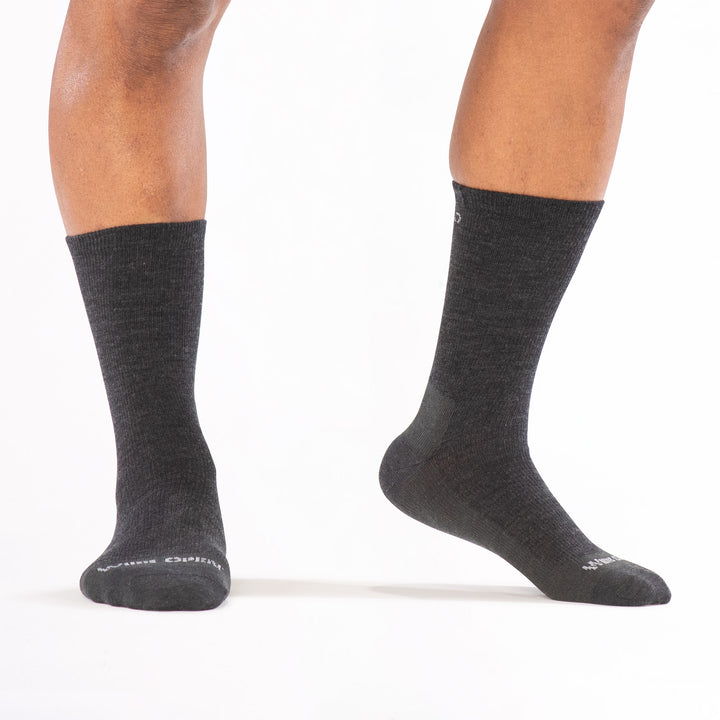 models feet standing with right foot lifted wearing the 9012 solid lightweight crew in charcoal