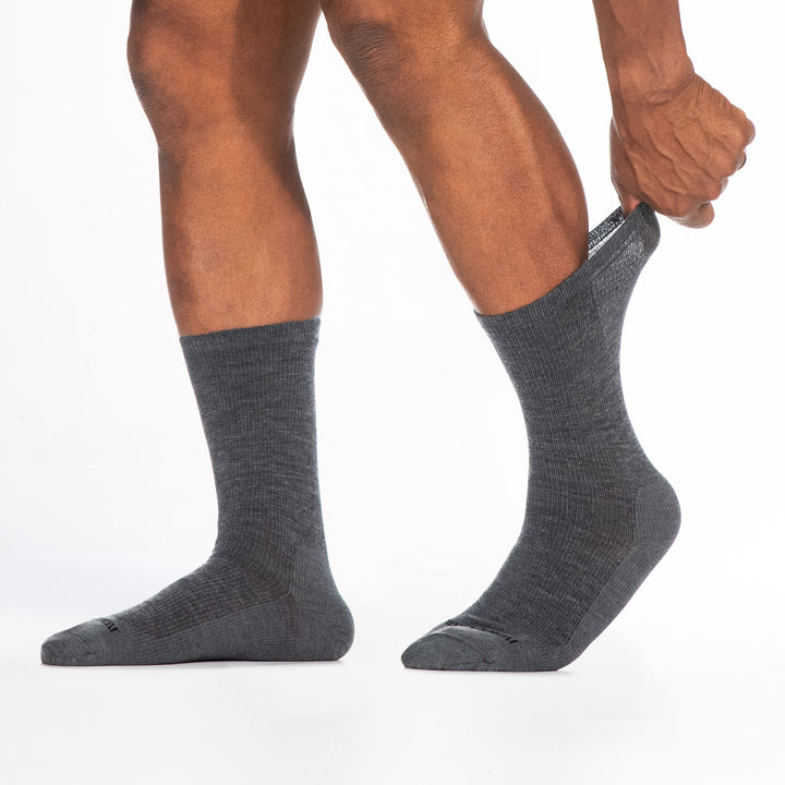 9012 gray crew sock with black logo shown from the side feet to the left back cuff stretched
