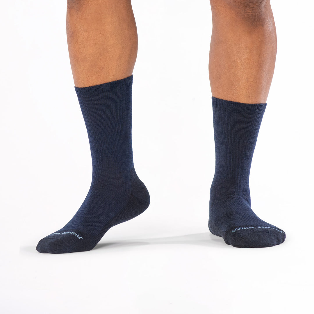 Models feet lifting the left foot wearing the 9012 solid lightweight crew in navy