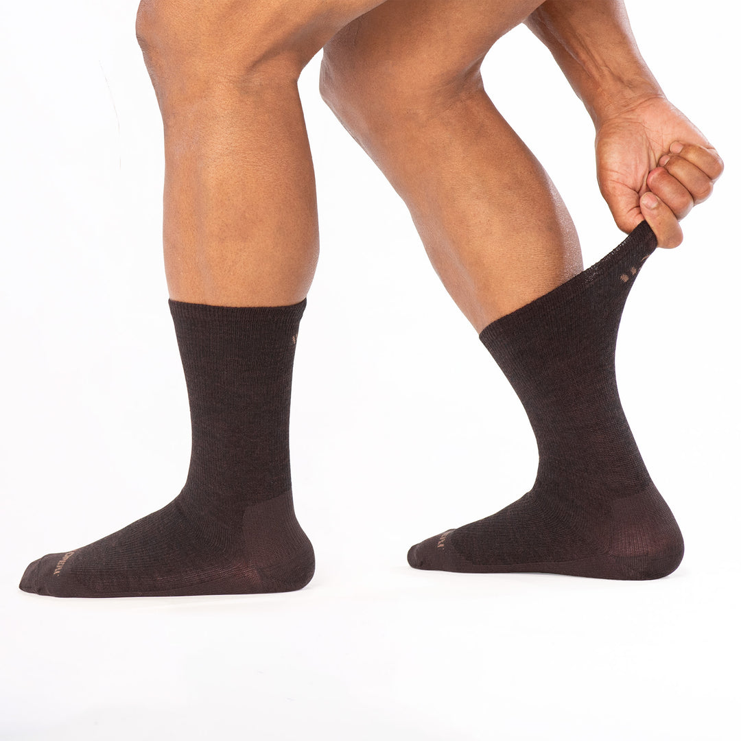 model stretching the calf on the back foot wearing the 9012 solid lightweight crew in walnut