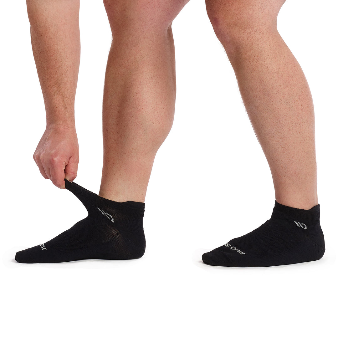 Models feet point left, stretching the cuff of the 9013 solid lightweight ankle sock in black