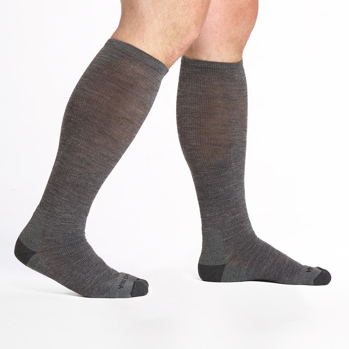 9017 gray knee high sock with charcoal heel/toe/logo shown from the side with back heel lifted