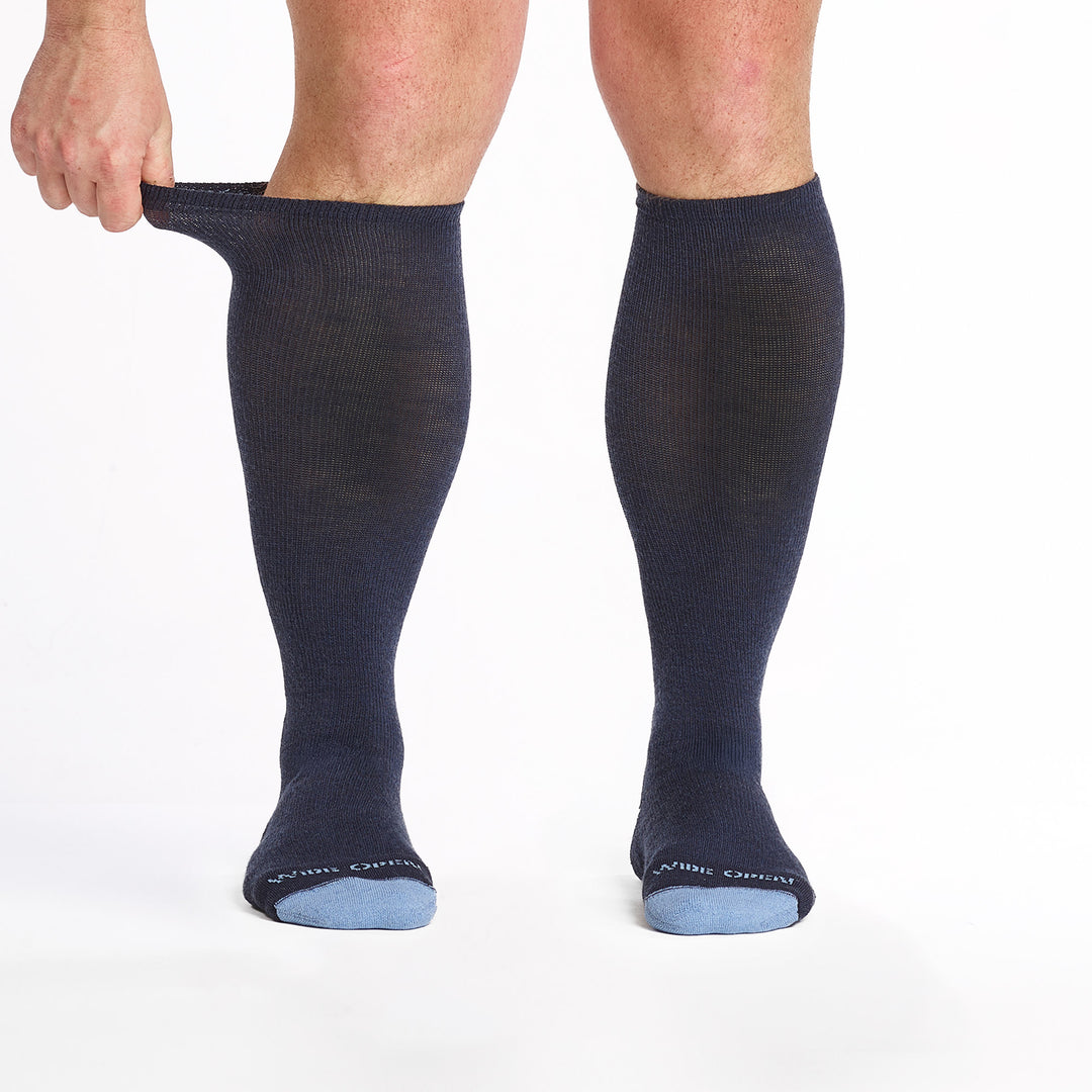 9017-navy knee high socks with light blue heel/toe/logo shown from the front the cuff being stretched