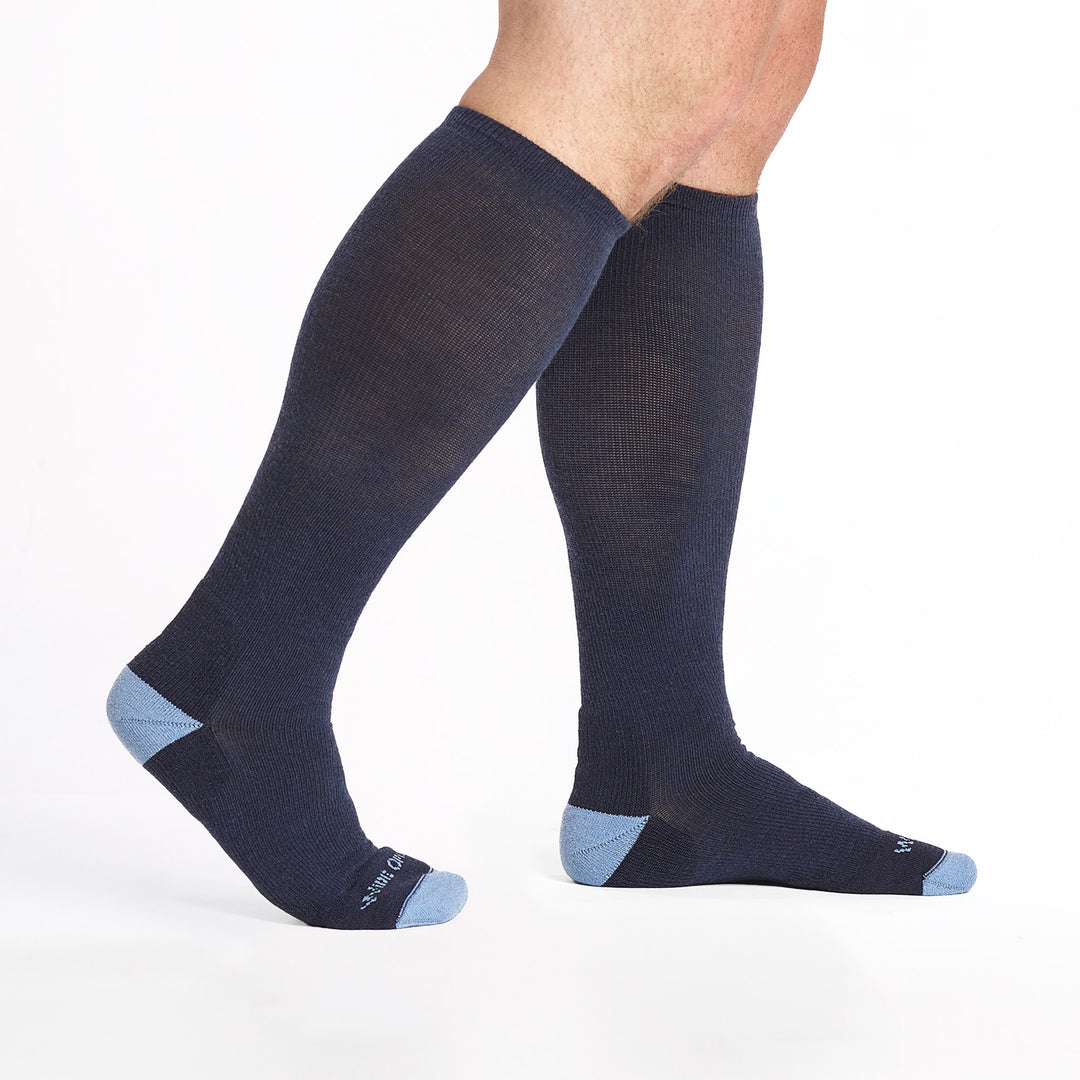 9017 Navy Knee high sock with light blue heel/toe/logo, shown walking to the right