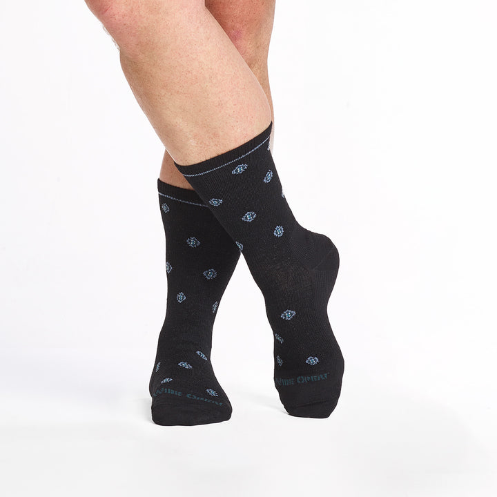 9018 black crew sock with dark teal logo, white geometric dots shown from the front with legs crossed