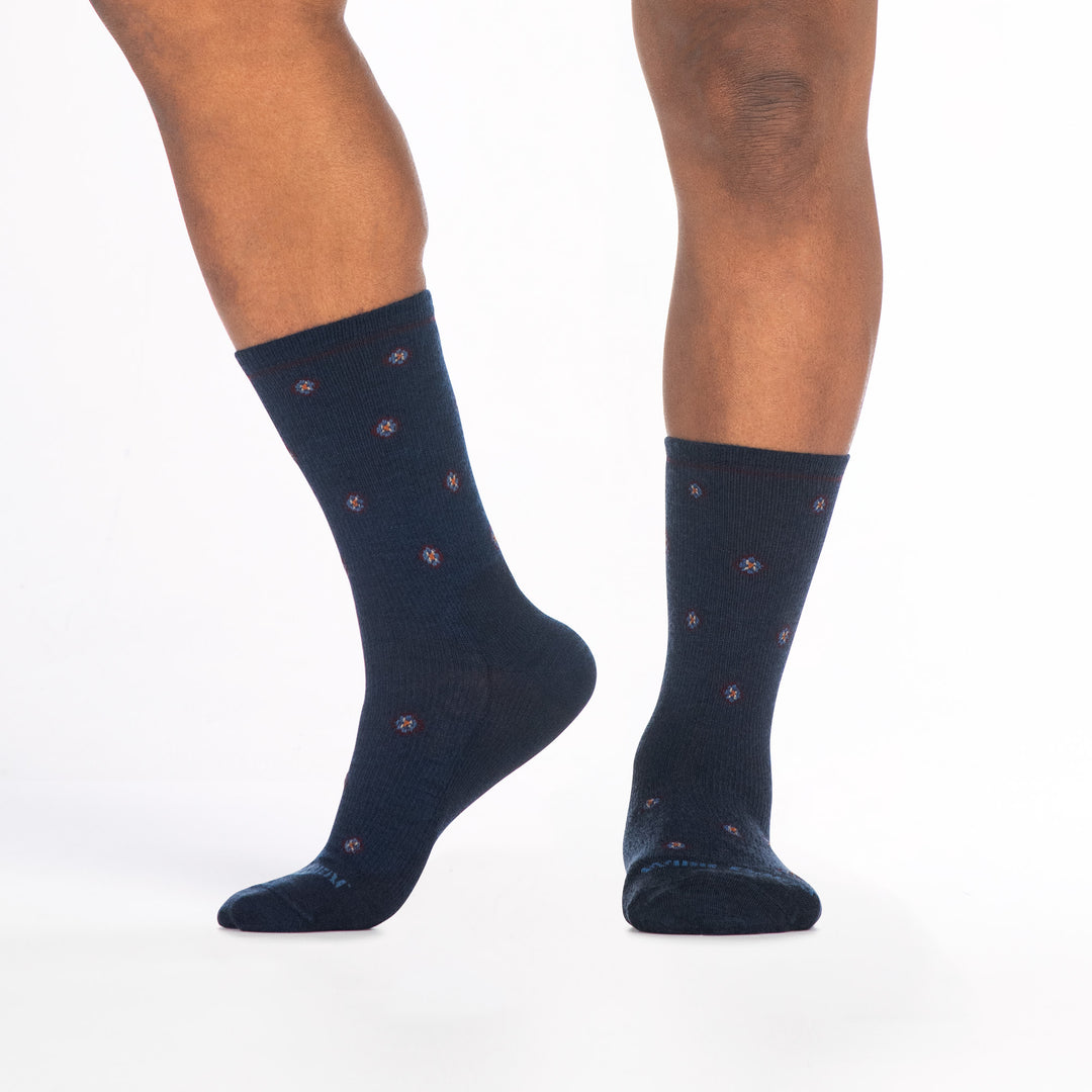 9018 navy crew sock with teal logo, light blue geometric dots, shown from the front and side with left foot raised