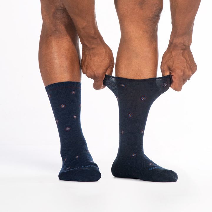 9018 navy crew sock with teal logo, light blue geometric dots, shown from the front with right cuff stretched