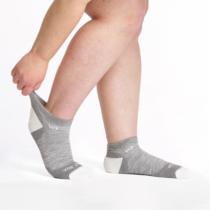 9500 lt gray ankle with white heel/toe/logo shown from the side feet to the right with back cuff stretched