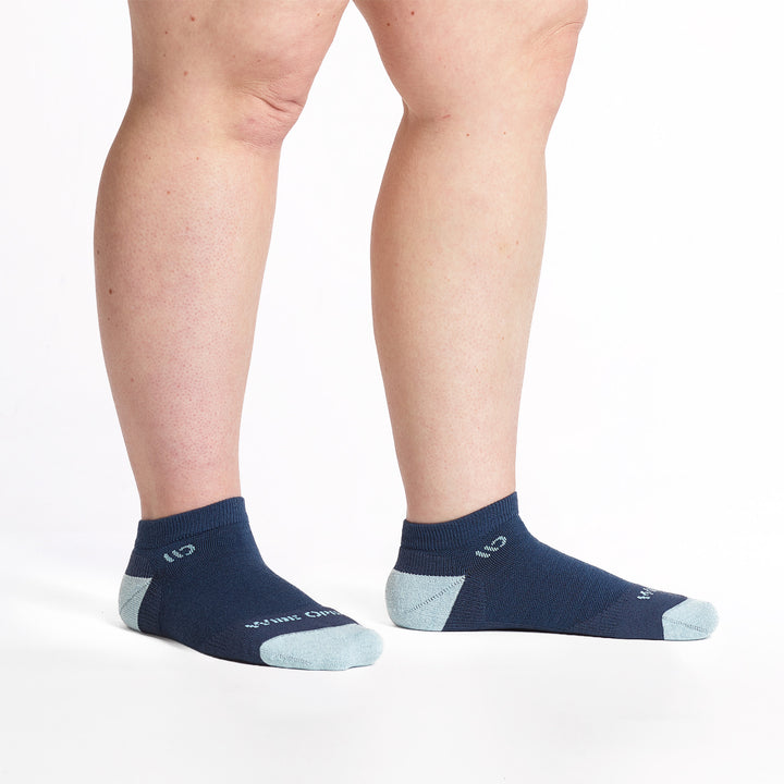 9500-Navy ankle sock with light blue heel/toe/logo, shown with feet to the right side.
