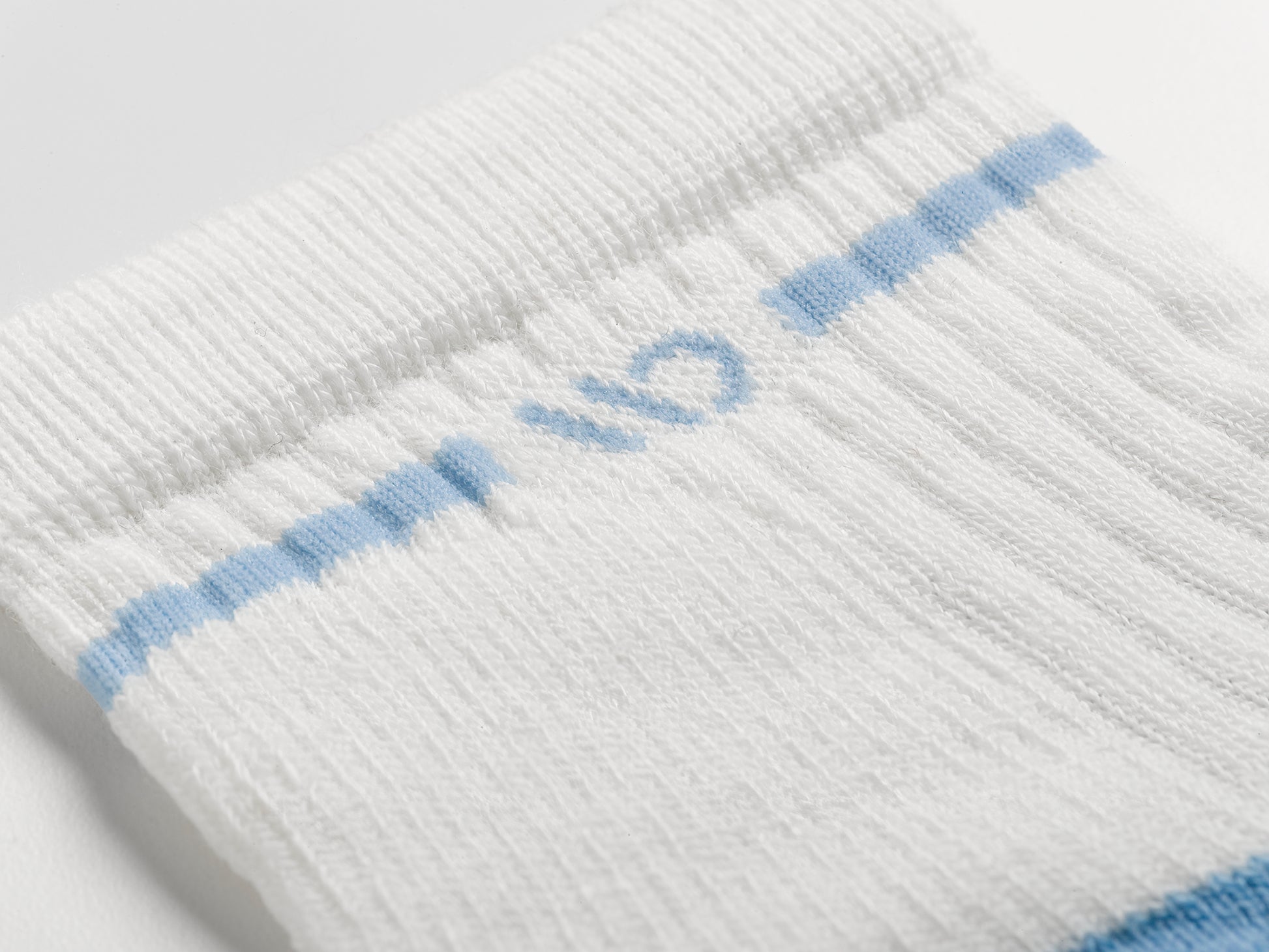 Detail featuring a blue logo and a blue stripe around the cuff--White