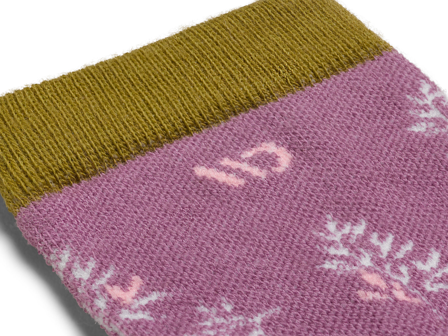 Detail featuring a pink logo, white foliage, and gold cuff--Violet