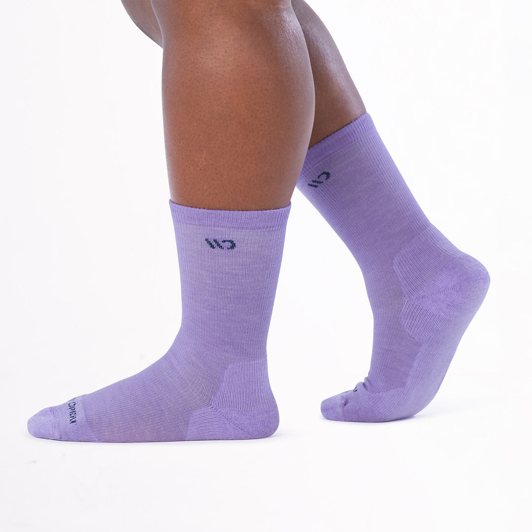 Model walking to the left with back foot lifted wearing the 9504 in lavender