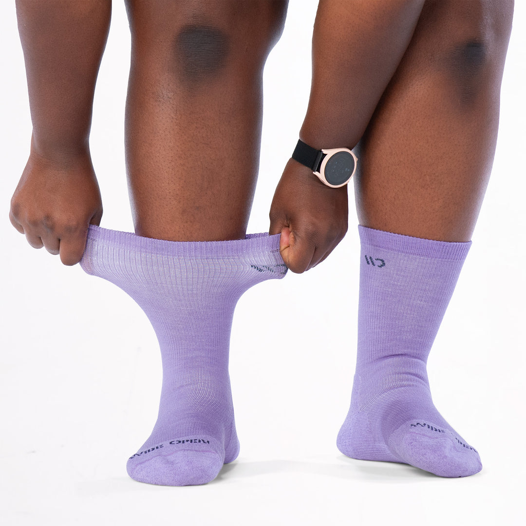 Model stretching the cuff on the 9504 solid cushioned crew in lavender