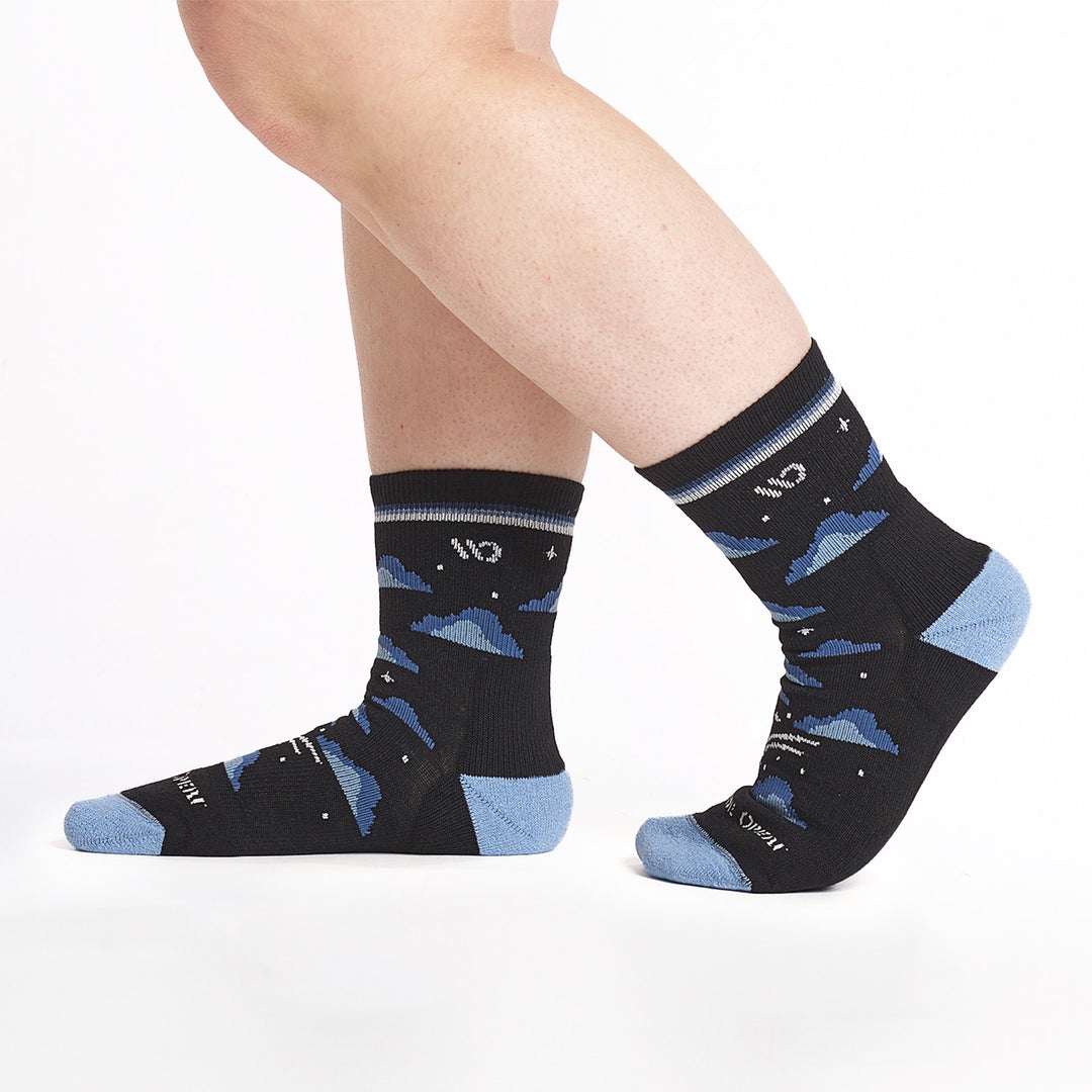 9508 black micro crew sock with lt blue heel/toe, white logo, blue clouds and stars, shown from the side pointing to left with back heel lifted