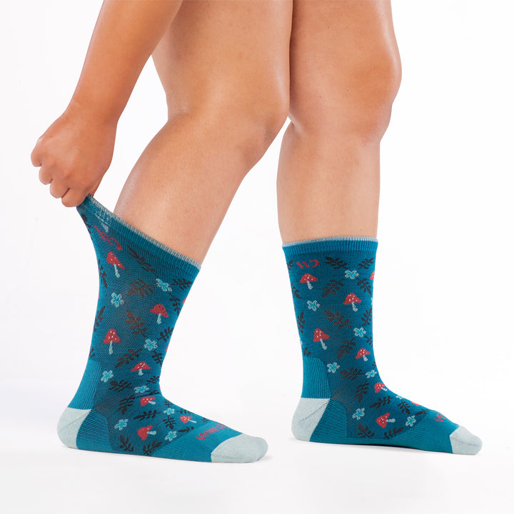 models feet to the right with stretching back cuff of the 9512 wildwood cushioned crew in teal