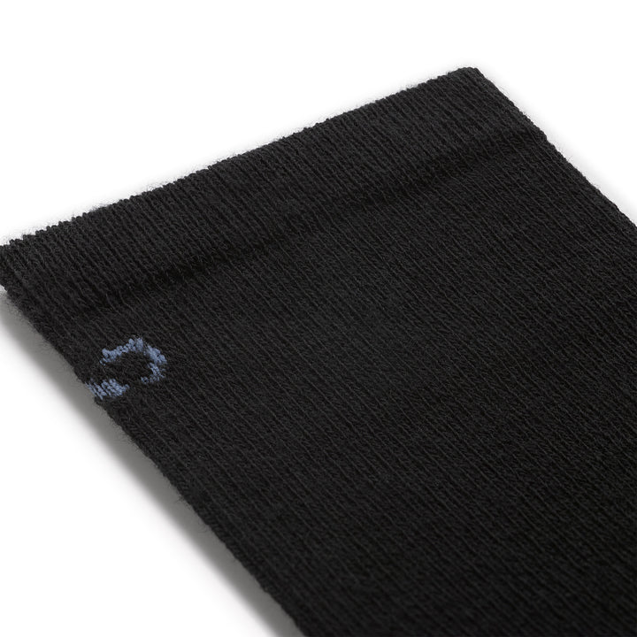 close up detail image of the 9513 solid basic lightweight crew in black featuring a light blue logo on black body