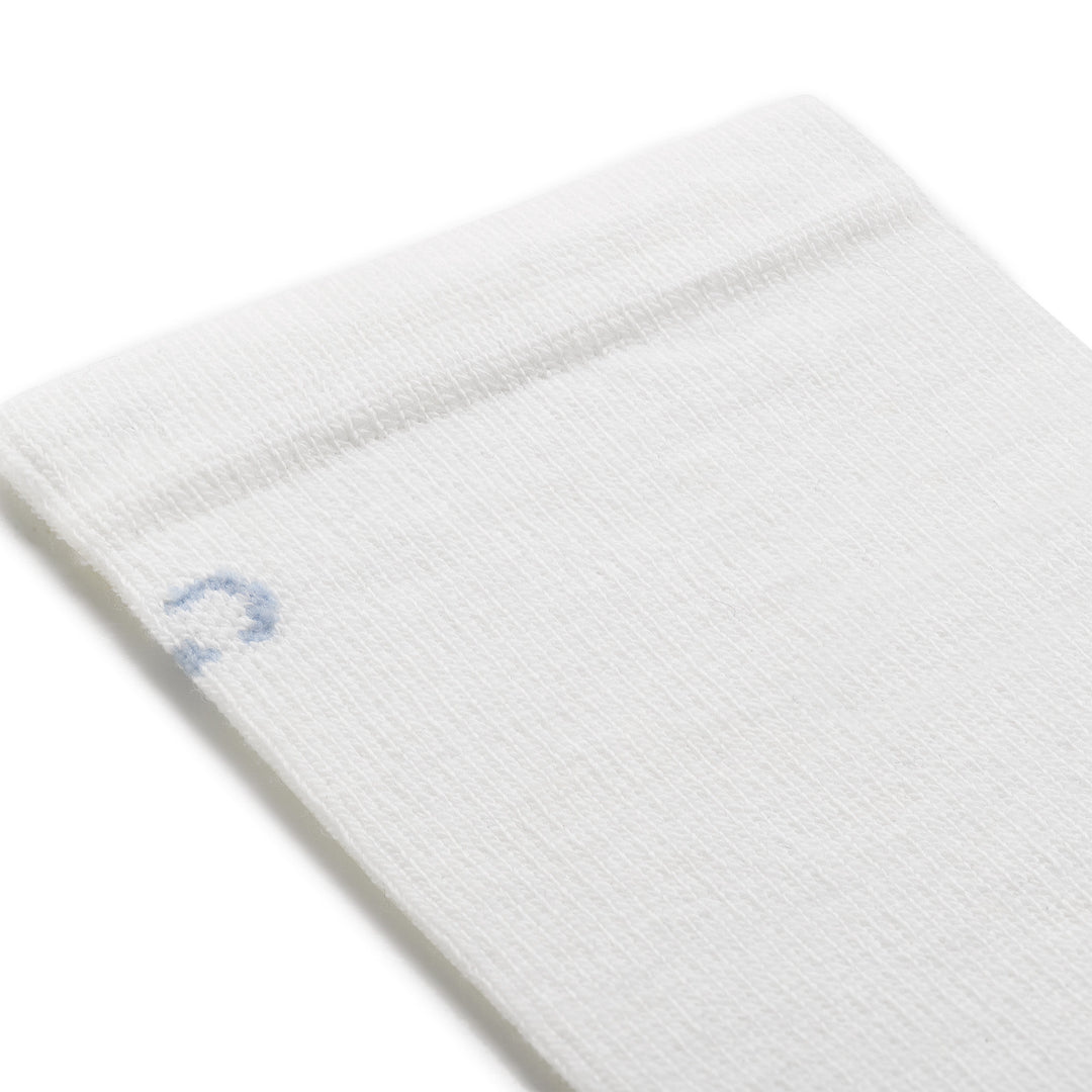 close up detail image of 9513 solid dbasic lightweight crew in white featuring a light blue logo and white body