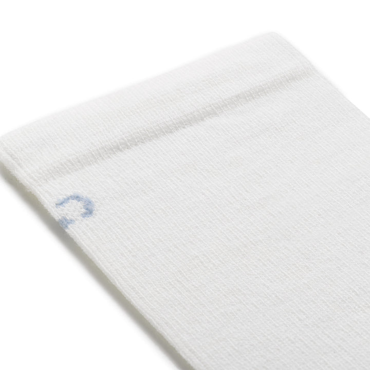 close up detail image of 9513 solid dbasic lightweight crew in white featuring a light blue logo and white body