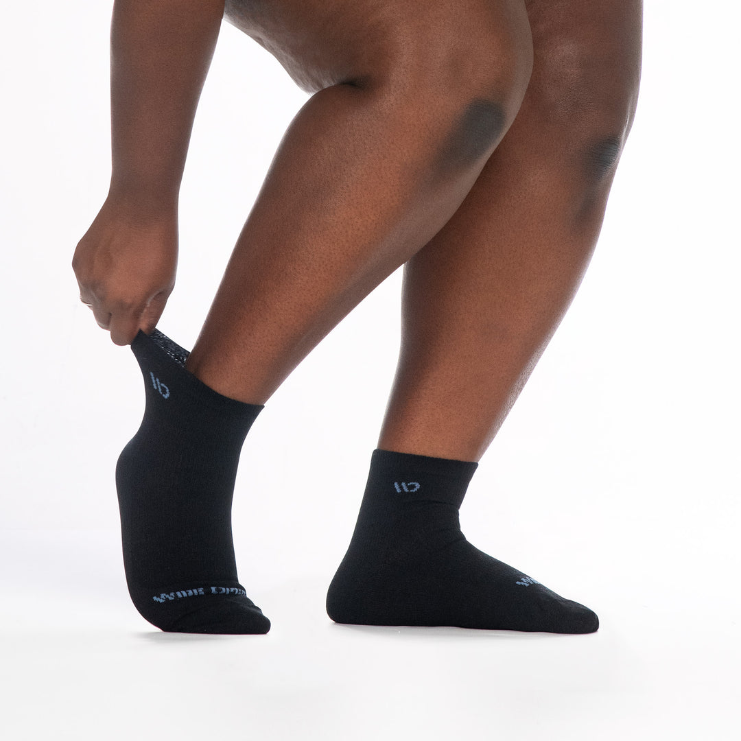 9515 black quarter sock with blue logo, shown from the side feet pointed right back cuff stretched