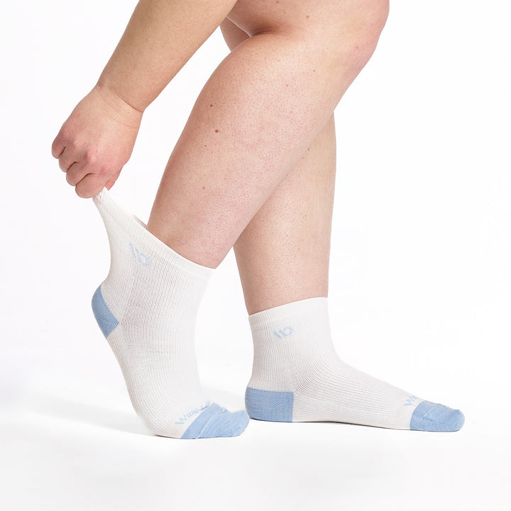 9515 White quarter sock with light blue heel/toe/logo shown from the side with back foot heel rasied and cuff stretched