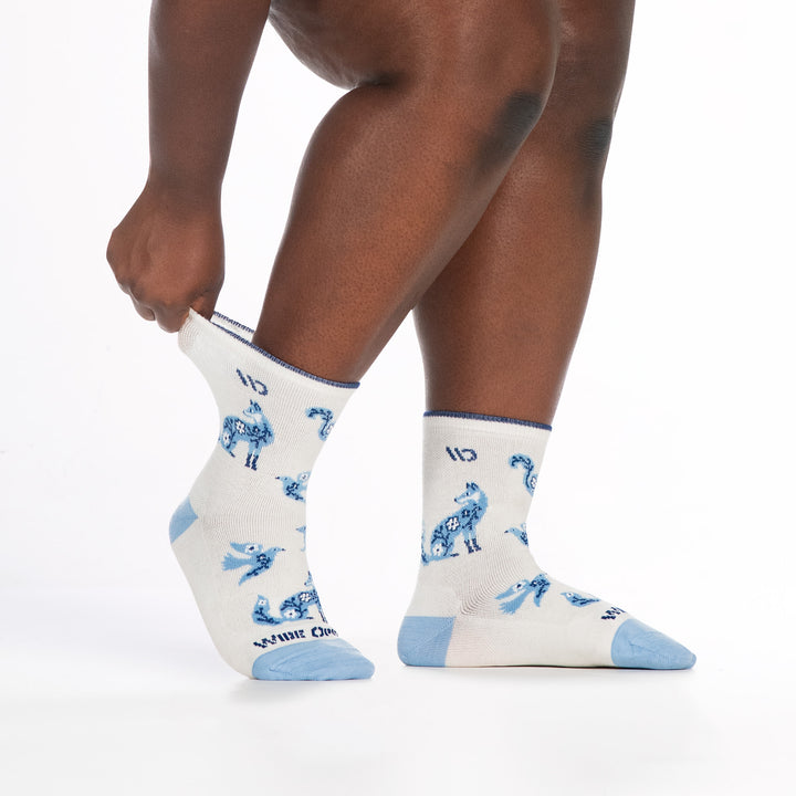 9516 white micro crew sock with lt blue heel/toe/design, dark blue logo, shown from side with back cuff being stretched
