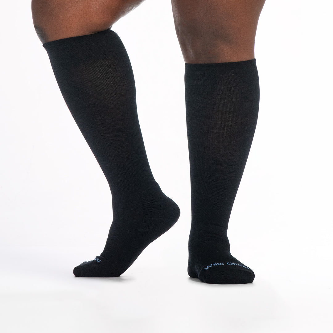 9517 black knee high sock with blue logo, shown from front and side with left foot raised